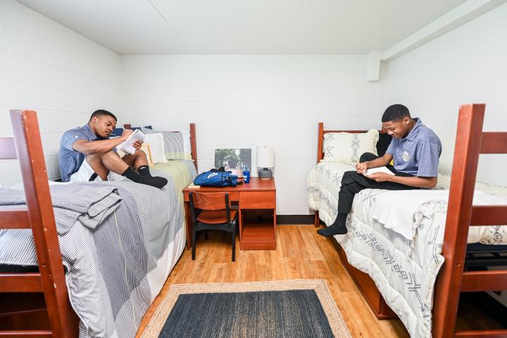 two male students on the beds in residence hall bedroom two male students on the beds in residence hall bedroom