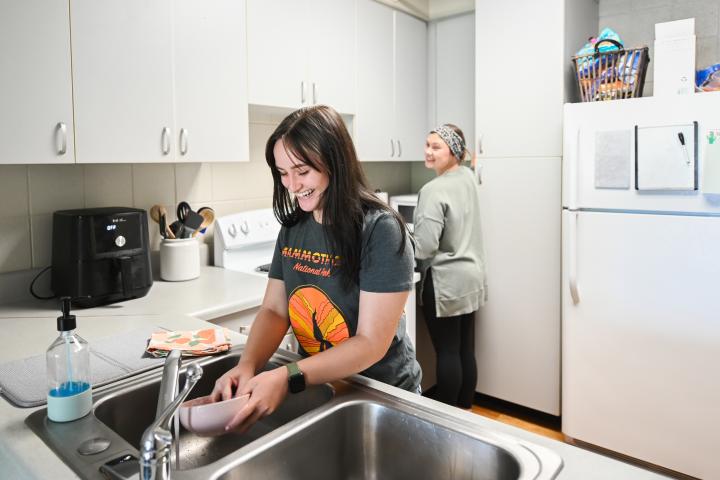 two roommates in kitchen, washing dishes two roommates in kitchen, washing dishes