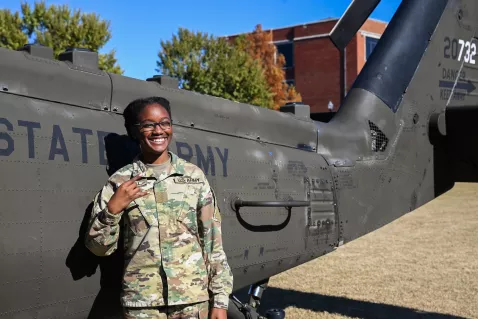 UTC Military Sciences and Leadership student standing in front of a blackwing helicopter